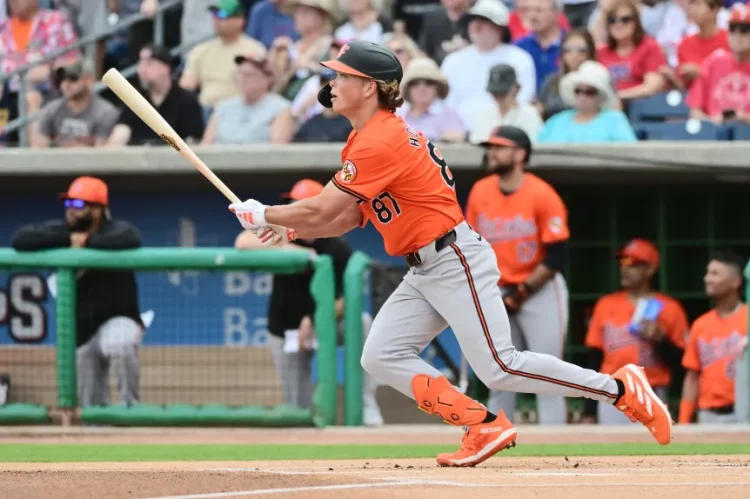 Jackson Holliday finishing a swing and running to first base