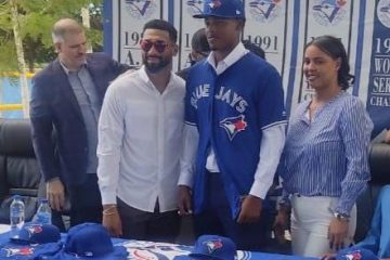 Blue Jays Prospect Juan Sanchez standing with parents after signing contract