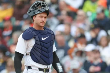 Dillon DIngler in catching gear, face mask on his head.
