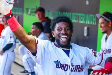 Kaelen Culpepper in the dugout waving towards the camera