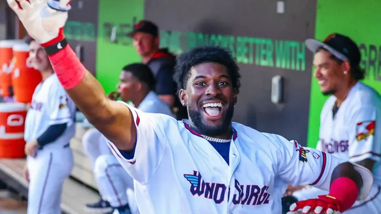 Kaelen Culpepper in the dugout waving towards the camera